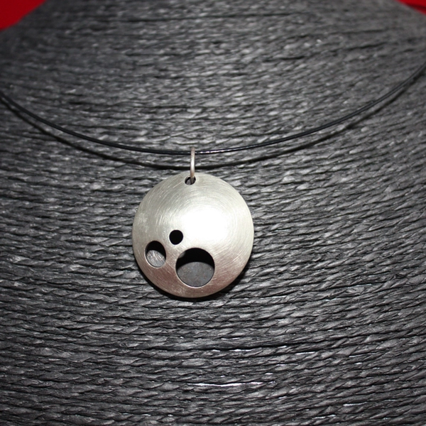 Pendentif emboutis avec trous. Intérieur oxydé